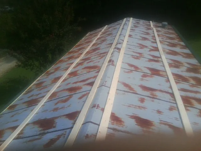Rusted metal roof panels with new wood purlins before replacement — Storm Damage Roof Repair in Hosford by Roofing Brothers