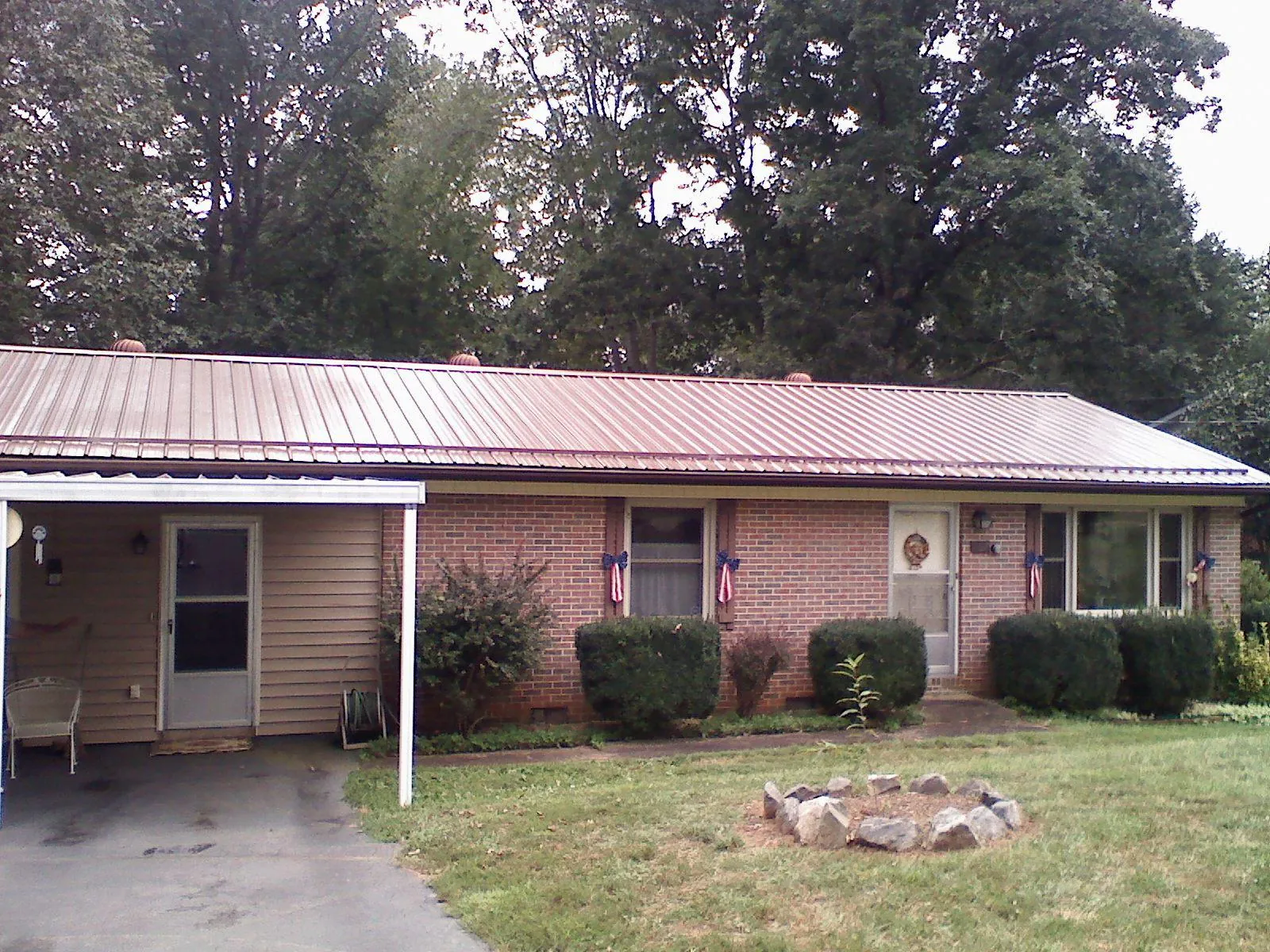 Bronze metal roof and carport on a brick ranch home — Roof Repair work by our crew in Hosford