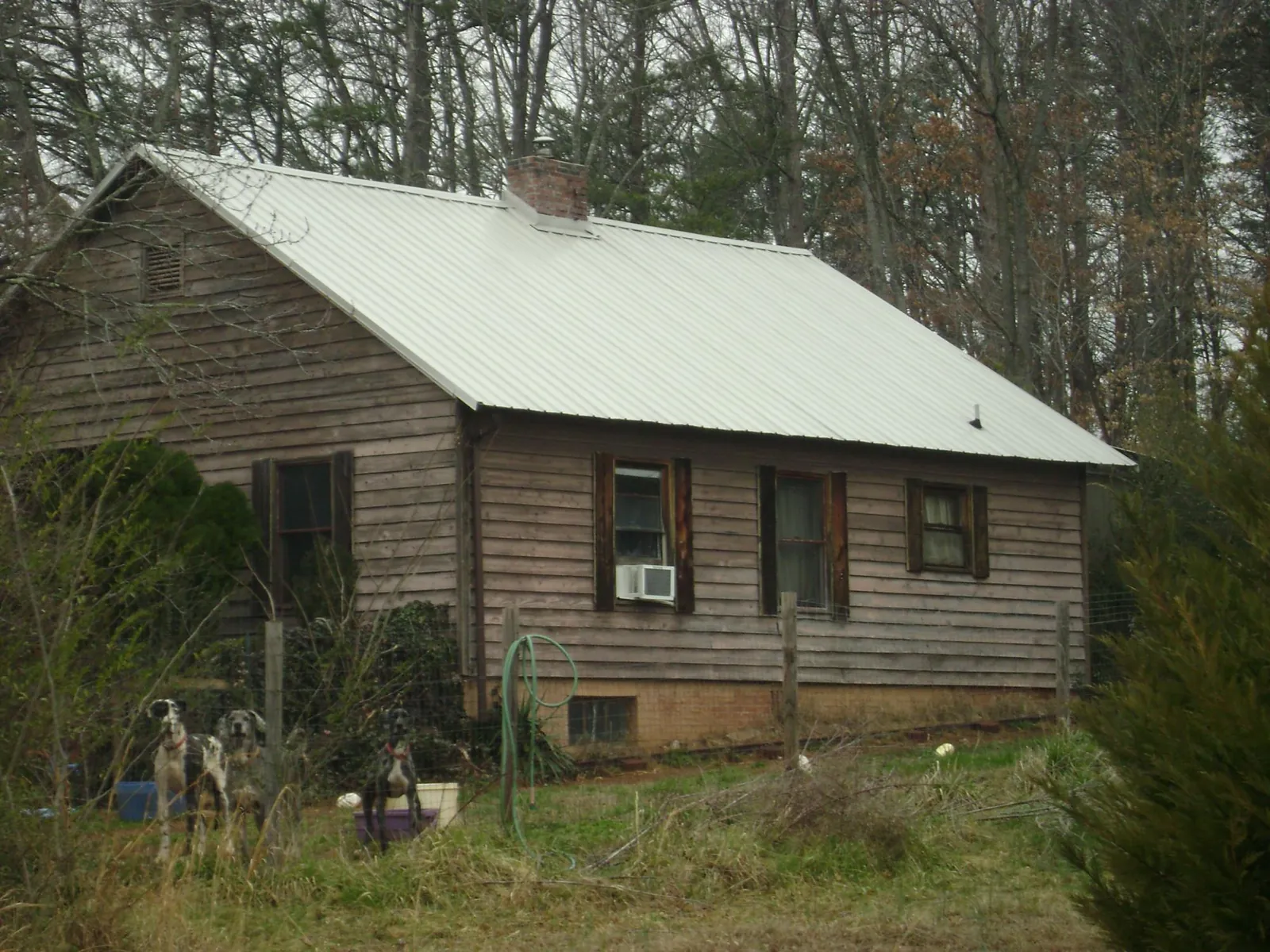 White metal roof on an old wood sided farmhouse, from a Metal Roof Installation job in Hosford